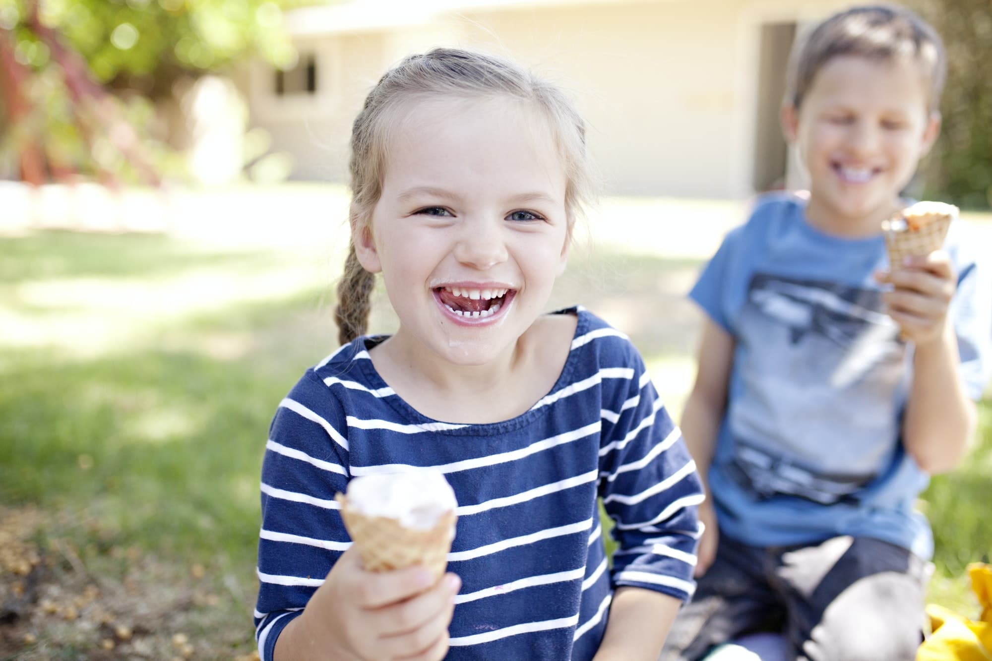 kids eating ice cream cones outside and laughing