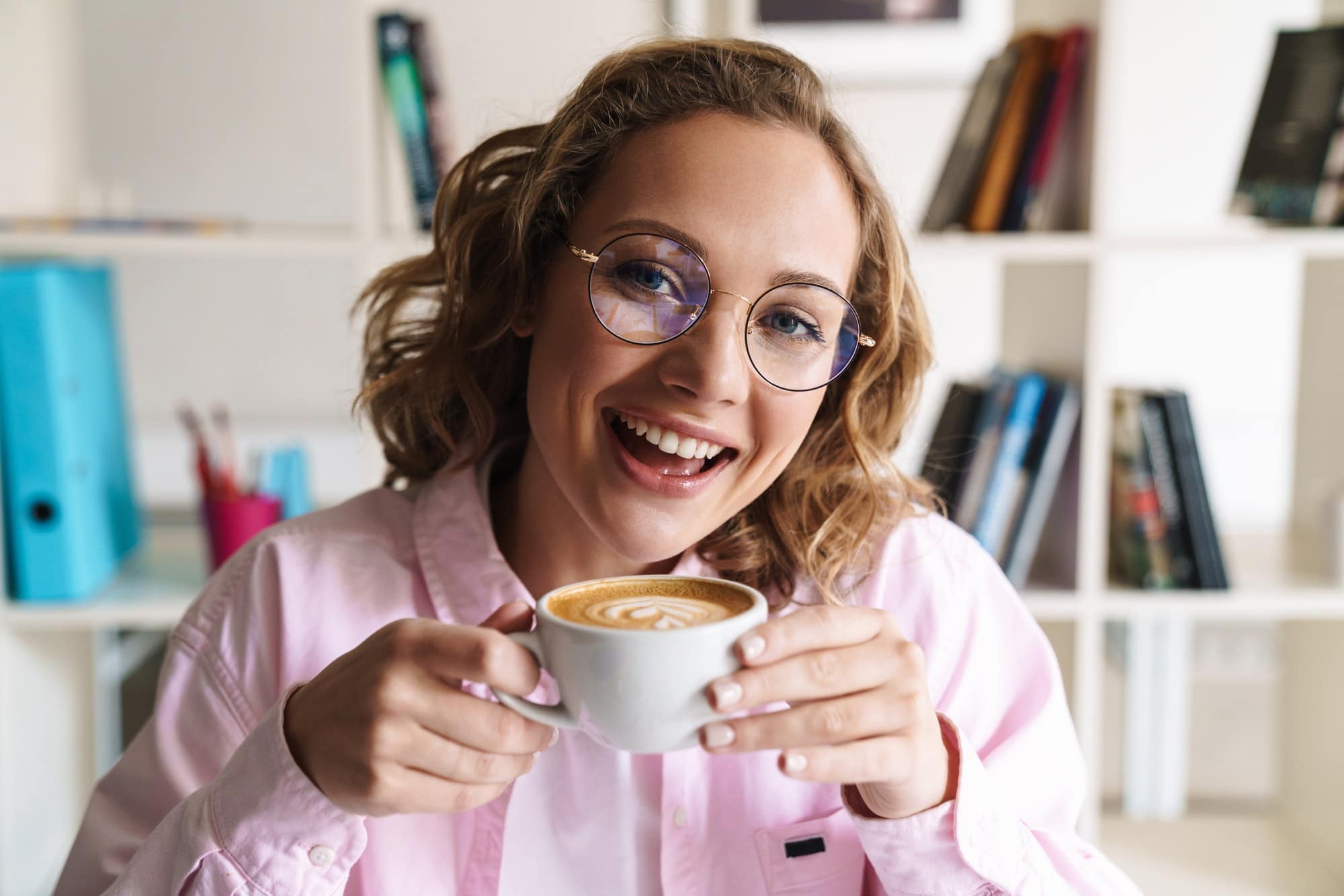 Photo of cheerful nice woman smiling and drinking coffee
